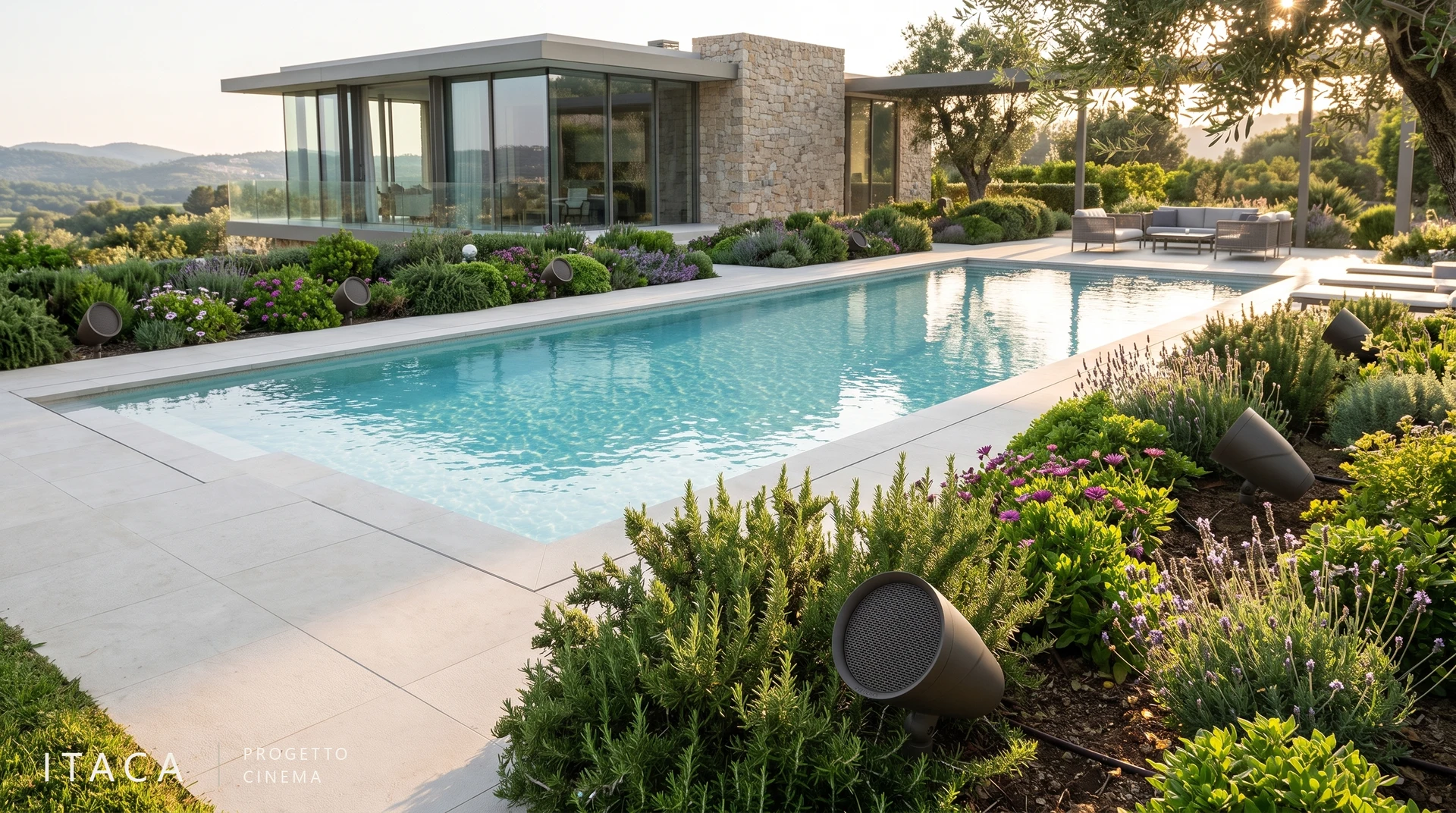I punti di diffusione sono distribuiti tra vegetazione e bordo piscina Diffusori con griglia circolare tra le aiuole di un giardino con piscina.